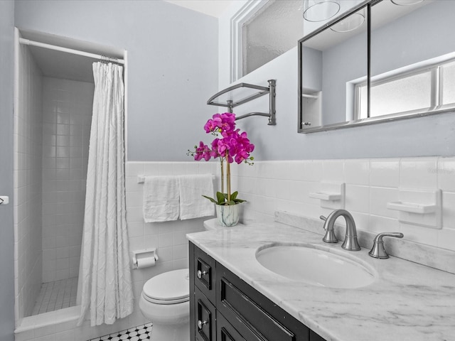 2244 Brookshire Ave, Winter Park, FL 32792 - bathroom featuring vanity, tile walls, tiled shower, wainscoting, and tile patterned flooring