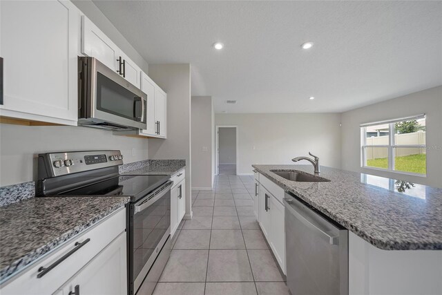 489 Panaro Ln, Haines City, FL 33844 - kitchen featuring appliances with stainless steel finishes, a sink, dark stone countertops, white cabinets, and recessed lighting