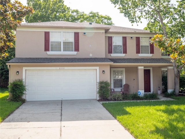 8330 Lainie Ln, Orlando, FL 32818 - view of front of house featuring a garage, driveway, a front yard, and stucco siding