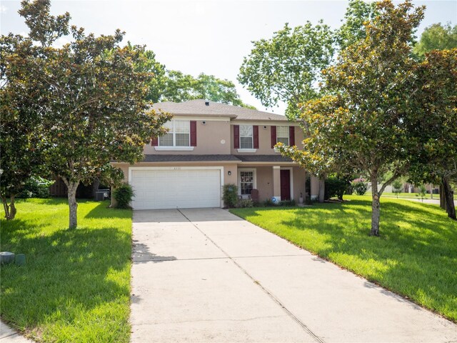 8330 Lainie Ln, Orlando, FL 32818 - view of front of house with concrete driveway, stucco siding, an attached garage, and a front lawn