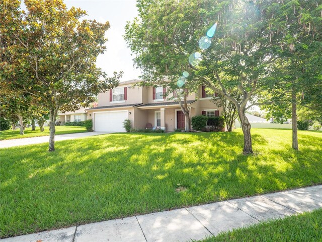 8330 Lainie Ln, Orlando, FL 32818 - view of front of property featuring an attached garage, a front yard, stucco siding, and concrete driveway