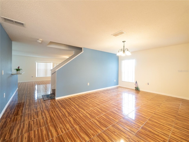 8330 Lainie Ln, Orlando, FL 32818 - empty room with a chandelier, stairs, and a textured ceiling
