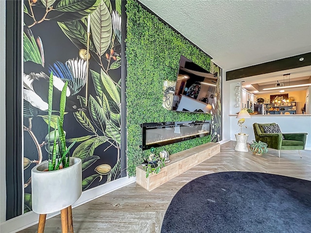 6336 Buford St Unit 207, Orlando, FL 32835 - living room featuring a glass covered fireplace, wood finished floors, and a textured ceiling