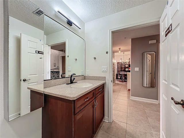 6336 Buford St Unit 207, Orlando, FL 32835 - bathroom with vanity, tile patterned flooring, ensuite bathroom, a textured ceiling, and a chandelier