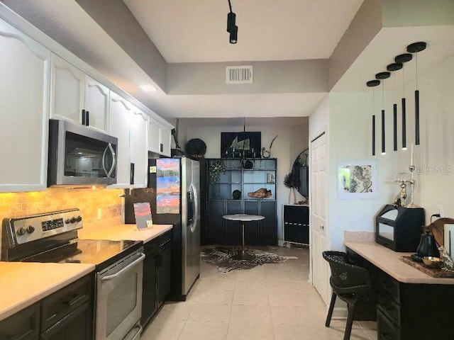 6336 Buford St Unit 207, Orlando, FL 32835 - kitchen featuring stainless steel appliances, white cabinetry, tasteful backsplash, light countertops, and light tile patterned floors