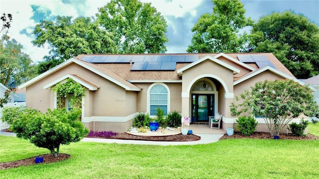 14723 Pine Cone Trl, Clermont, FL 34711 - view of front of property with roof with shingles, solar panels, a front yard, and stucco siding
