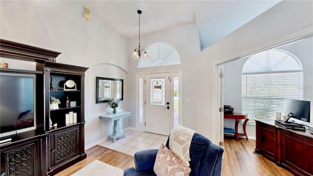 14723 Pine Cone Trl, Clermont, FL 34711 - entrance foyer with a chandelier, light wood-style floors, and a towering ceiling