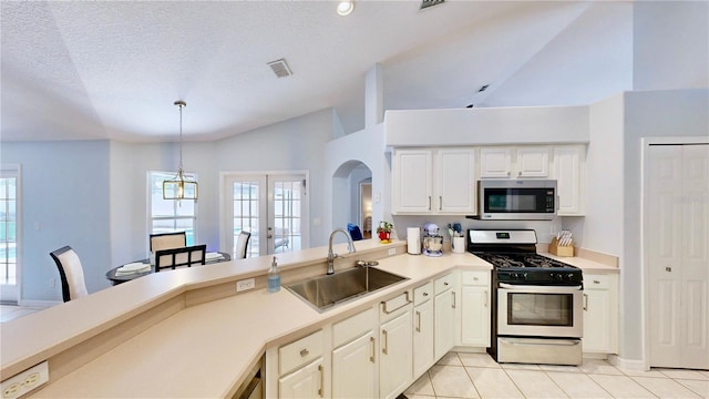 14723 Pine Cone Trl, Clermont, FL 34711 - kitchen featuring appliances with stainless steel finishes, light tile patterned floors, light countertops, arched walkways, and a peninsula