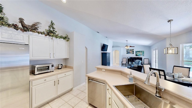 14723 Pine Cone Trl, Clermont, FL 34711 - kitchen with stainless steel appliances, ceiling fan, vaulted ceiling, pendant lighting, and white cabinets