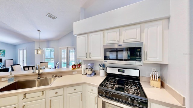 14723 Pine Cone Trl, Clermont, FL 34711 - kitchen featuring stainless steel appliances, lofted ceiling, white cabinets, hanging light fixtures, and light countertops