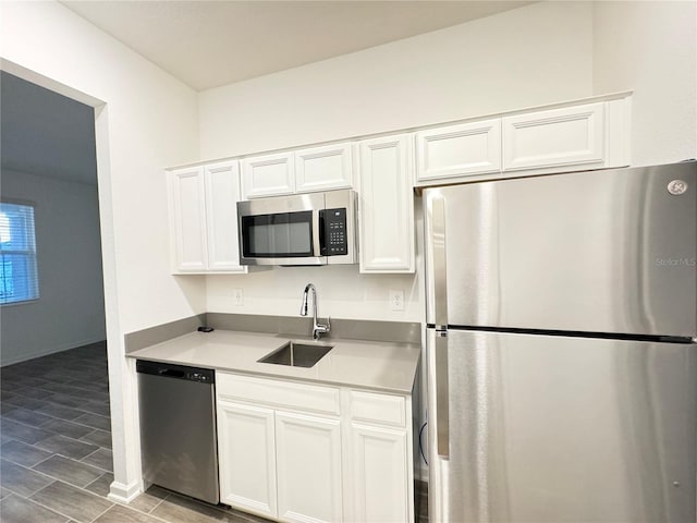 1147 Pomelo St, Davenport, FL 33837 - kitchen with stainless steel appliances, a sink, white cabinets, light countertops, and light wood-style flooring