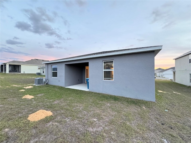 1147 Pomelo St, Davenport, FL 33837 - back of house with stucco siding, a patio, a yard, and central AC