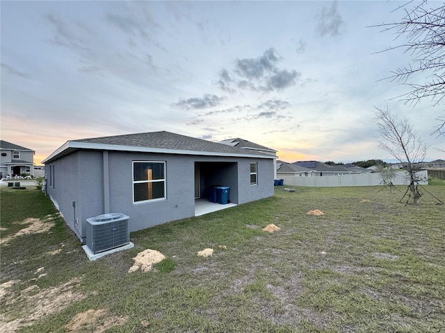 1147 Pomelo St, Davenport, FL 33837 - rear view of house featuring central AC, stucco siding, a shingled roof, and a patio area