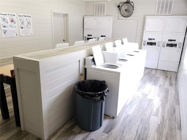 1000 S Semoran Blvd Unit 415, Winter Park, FL 32792 - shared laundry with stacked washer / dryer, light wood-style flooring, and wooden walls