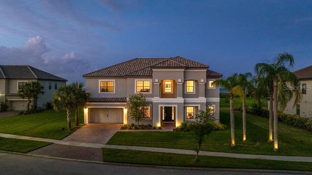 1551 Gateway Ln, Kissimmee, FL 34746 - mediterranean / spanish home featuring a tile roof, stucco siding, decorative driveway, and a front yard