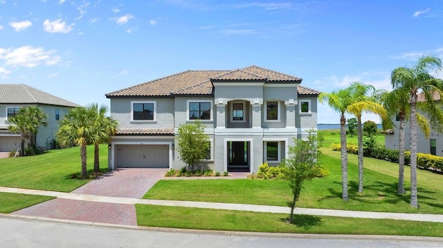 1551 Gateway Ln, Kissimmee, FL 34746 - mediterranean / spanish-style house featuring stucco siding, a tiled roof, decorative driveway, a garage, and a front lawn