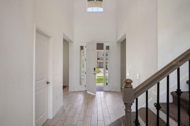 1551 Gateway Ln, Kissimmee, FL 34746 - foyer with a high ceiling, stairway, and light wood-style flooring