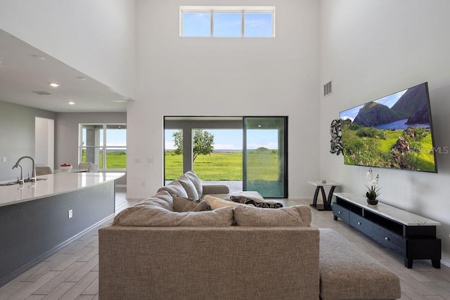 1551 Gateway Ln, Kissimmee, FL 34746 - living area featuring light wood finished floors, a towering ceiling, and recessed lighting