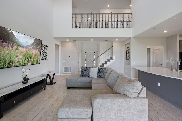 1551 Gateway Ln, Kissimmee, FL 34746 - living area with light wood finished floors, a high ceiling, and stairway