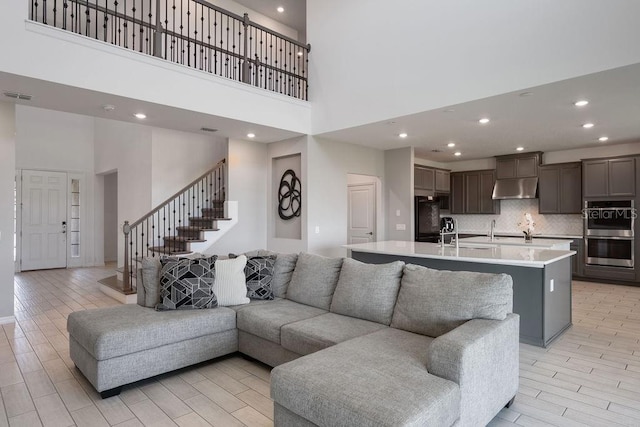 1551 Gateway Ln, Kissimmee, FL 34746 - living room featuring a towering ceiling, wood finish floors, stairway, and recessed lighting