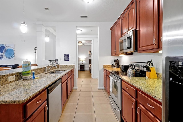 5024 Shoreway Loop Unit 10106, Orlando, FL 32819 - kitchen with appliances with stainless steel finishes, light tile patterned flooring, light stone counters, decorative light fixtures, and a peninsula
