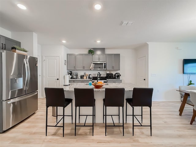 1471 Mirabella Cir, Davenport, FL 33897 - kitchen with appliances with stainless steel finishes, gray cabinetry, light wood finished floors, light stone countertops, and recessed lighting