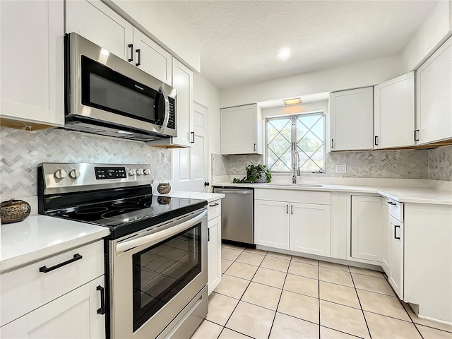 249 Spartan Dr, Maitland, FL 32751 - kitchen featuring stainless steel appliances, light countertops, white cabinetry, and a textured ceiling