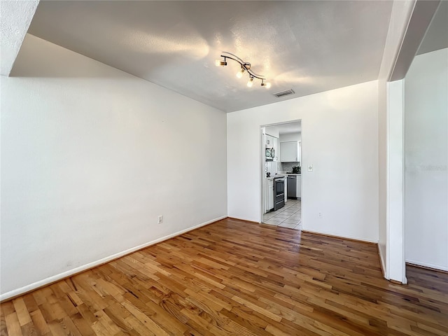 249 Spartan Dr, Maitland, FL 32751 - spare room with light wood-style floors and rail lighting