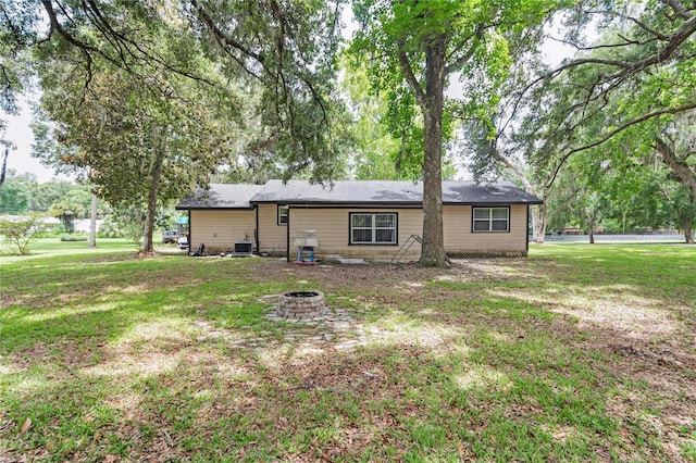 1753 NW 44th St, Ocala, FL 34475 - rear view of property with a fire pit, a lawn, and central AC