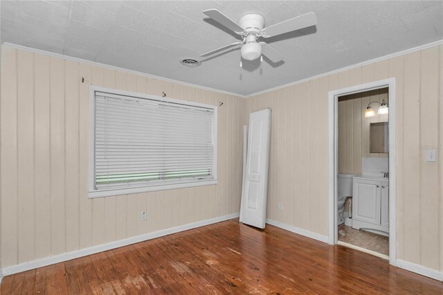 1753 NW 44th St, Ocala, FL 34475 - unfurnished bedroom with hardwood / wood-style flooring, ornamental molding, baseboards, wooden walls, and ensuite bath