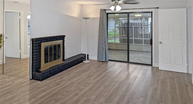 2804 Clearfield Ave, Orlando, FL 32808 - unfurnished living room featuring a ceiling fan, wood finished floors, and a brick fireplace