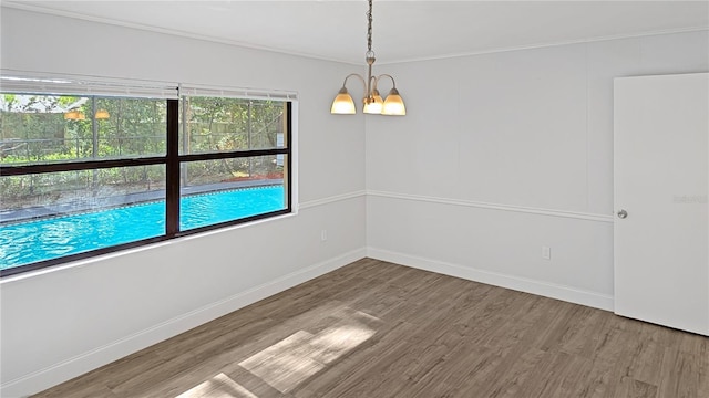 2804 Clearfield Ave, Orlando, FL 32808 - unfurnished room with wood finished floors, a chandelier, and crown molding