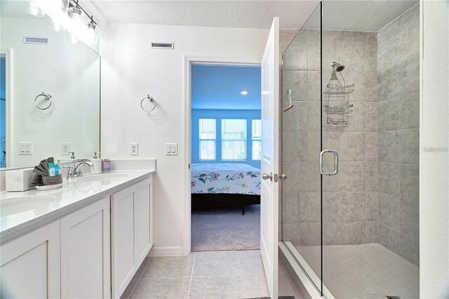 832 Longboat Dr, Davenport, FL 33896 - full bathroom featuring connected bathroom, a stall shower, double vanity, tile patterned flooring, and a textured ceiling
