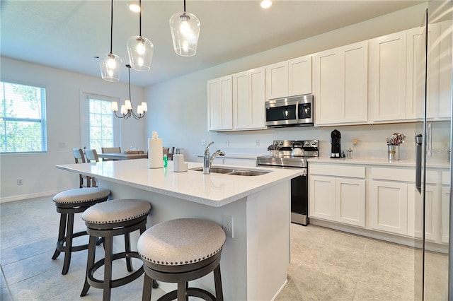 832 Longboat Dr, Davenport, FL 33896 - kitchen with appliances with stainless steel finishes, white cabinets, a breakfast bar, an island with sink, and recessed lighting