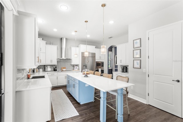 25537 High Hampton Cir, Sorrento, FL 32776 - kitchen featuring wall chimney exhaust hood, stainless steel appliances, a breakfast bar area, backsplash, and dark wood-type flooring