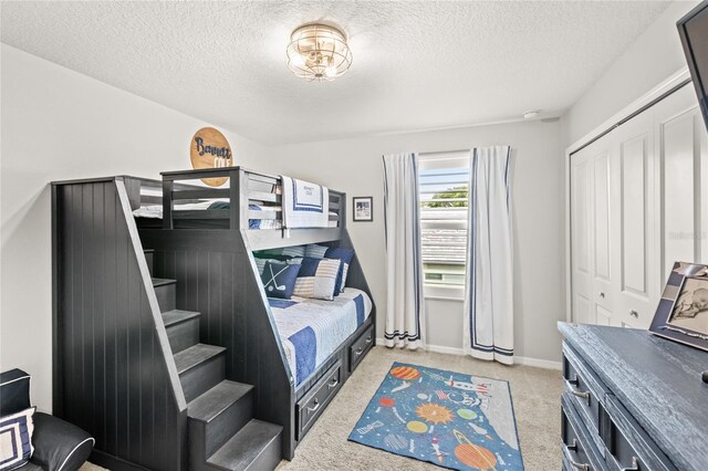 25537 High Hampton Cir, Sorrento, FL 32776 - bedroom with a textured ceiling, light carpet, a closet, and baseboards