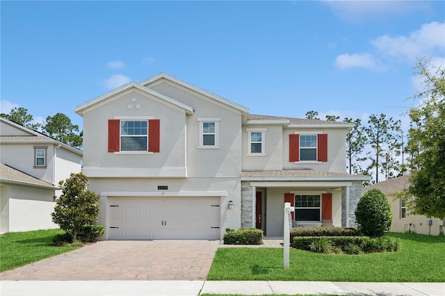 2279 Mountain Pine St, Ocoee, FL 34761 - traditional-style home featuring stucco siding, decorative driveway, a garage, and a front yard