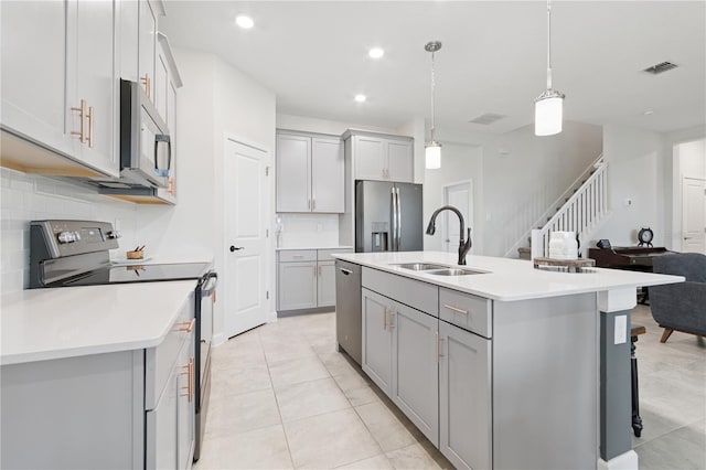 2279 Mountain Pine St, Ocoee, FL 34761 - kitchen with appliances with stainless steel finishes, gray cabinets, backsplash, a center island with sink, and recessed lighting