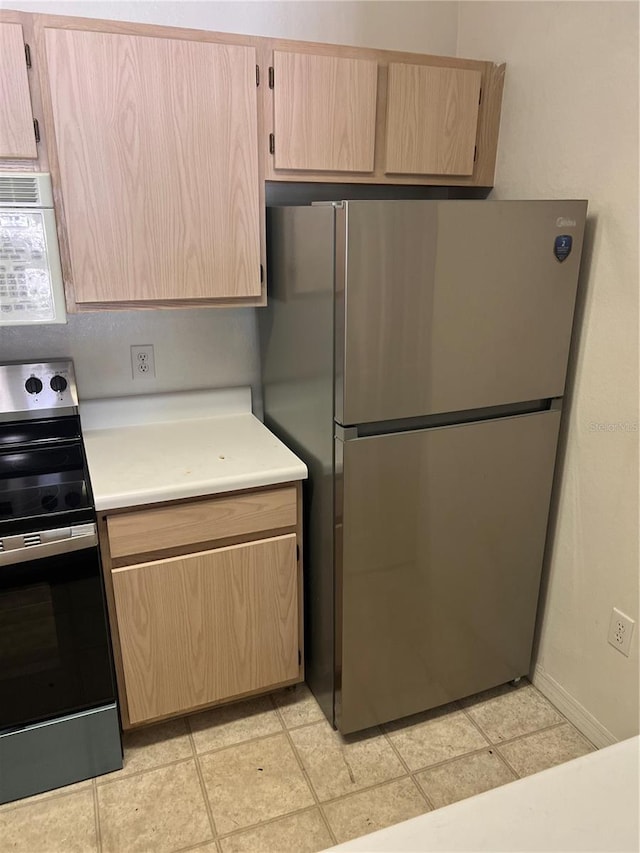 5459 Vineland Rd Unit 4310, Orlando, FL 32811 - kitchen with stainless steel appliances, light brown cabinets, light countertops, and baseboards