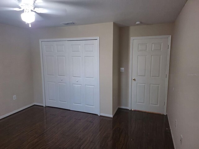 5459 Vineland Rd Unit 4310, Orlando, FL 32811 - unfurnished bedroom featuring wood finished floors, baseboards, a closet, and a ceiling fan