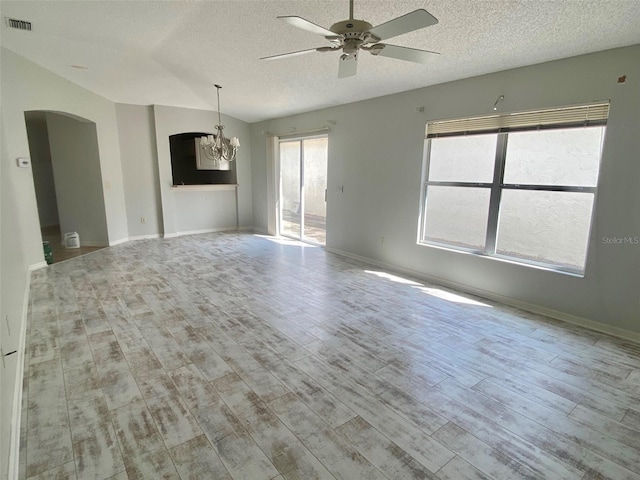 1524 Conway Ct, The Villages, FL 32162 - unfurnished room featuring a textured ceiling, a chandelier, arched walkways, ceiling fan, and wood finished floors