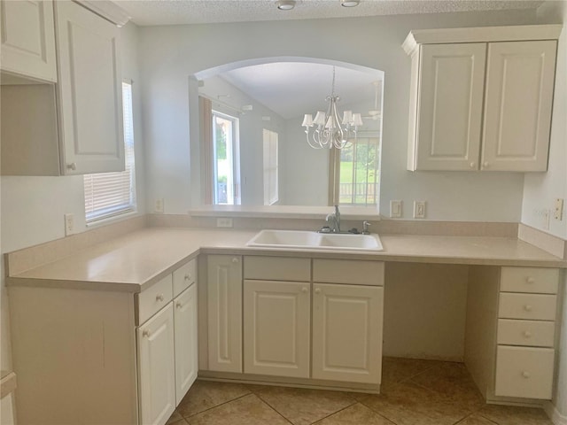 1524 Conway Ct, The Villages, FL 32162 - kitchen featuring a sink, arched walkways, light countertops, light tile patterned floors, and white cabinets