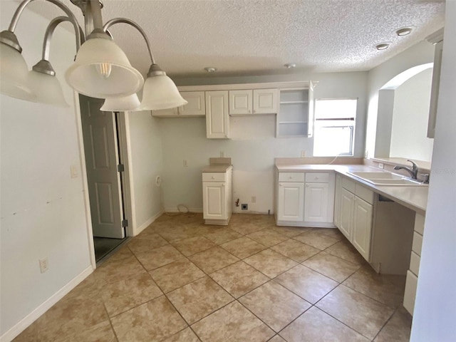 1524 Conway Ct, The Villages, FL 32162 - kitchen with a sink, arched walkways, a textured ceiling, light tile patterned flooring, and baseboards