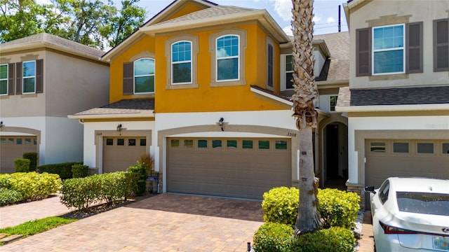 3508 Brighton Park Cir, Belle Isle, FL 32812 - view of front of property with a garage, stucco siding, decorative driveway, and a shingled roof
