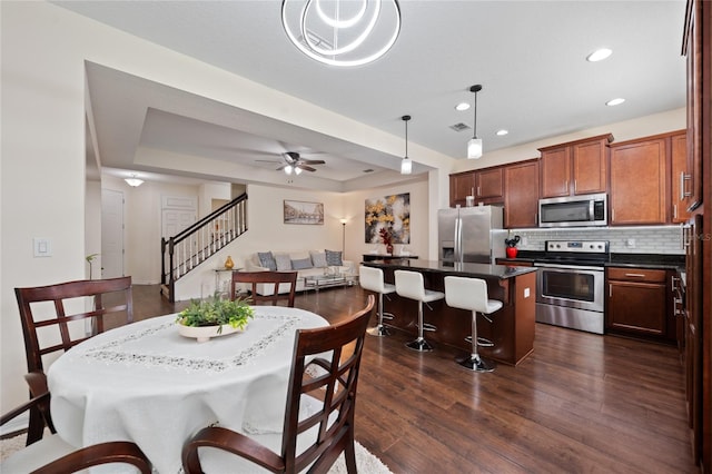 3508 Brighton Park Cir, Belle Isle, FL 32812 - dining area featuring stairway, dark wood-type flooring, recessed lighting, ceiling fan, and a tray ceiling
