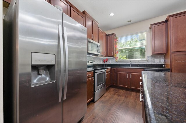 3508 Brighton Park Cir, Belle Isle, FL 32812 - kitchen with appliances with stainless steel finishes, dark wood finished floors, decorative backsplash, dark stone countertops, and recessed lighting
