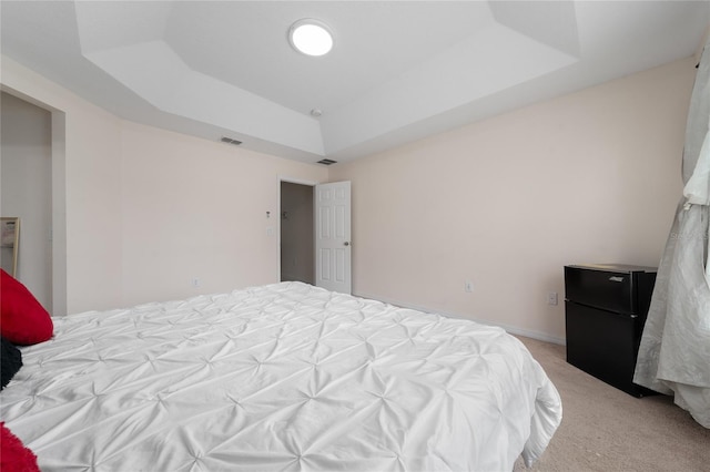 3508 Brighton Park Cir, Belle Isle, FL 32812 - bedroom featuring a tray ceiling, freestanding refrigerator, and light carpet
