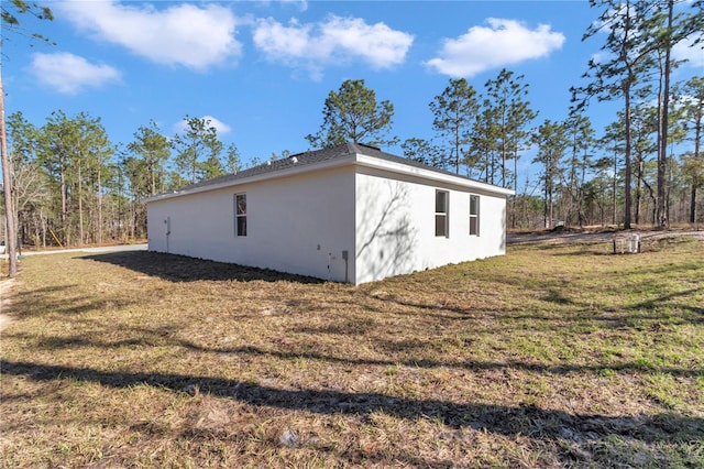 23430 SW Neptune Blvd, Dunnellon, FL 34431 - view of side of property with stucco siding and a yard