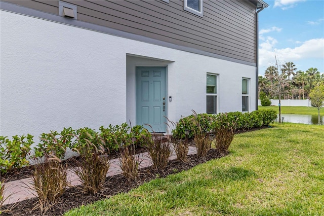 378 Cape Honeysuckle Pl, Sanford, FL 32771 - entrance to property with a yard, stucco siding, and a water view
