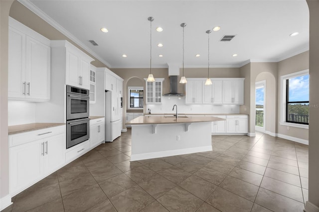 15344 Johns Lake Pointe Blvd, Winter Garden, FL 34787 - kitchen featuring double oven, wall chimney exhaust hood, dark tile patterned flooring, plenty of natural light, and recessed lighting